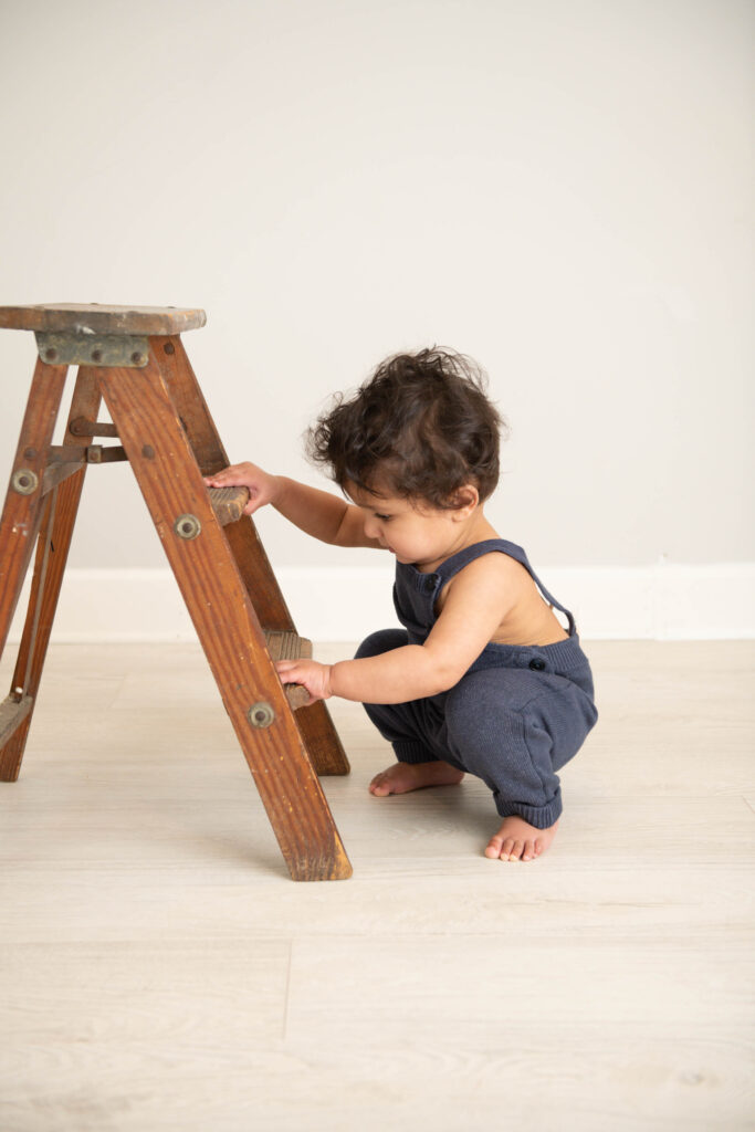 Philadelphia Pediatrician Dr. Meghna Patel baby with ladder in blue
overalls
