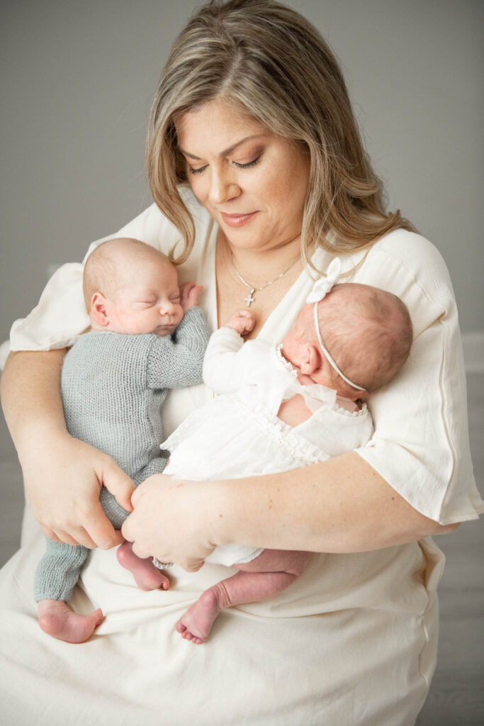 New mother sitting with her newborn twin babies