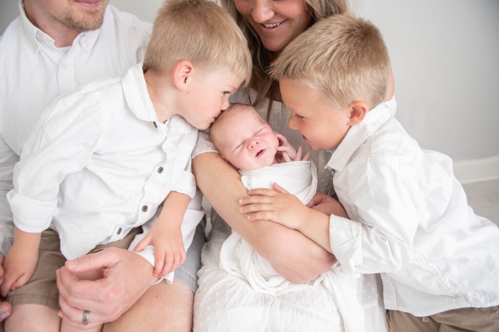 big brothers kiss little baby by Valerie Maria Photography