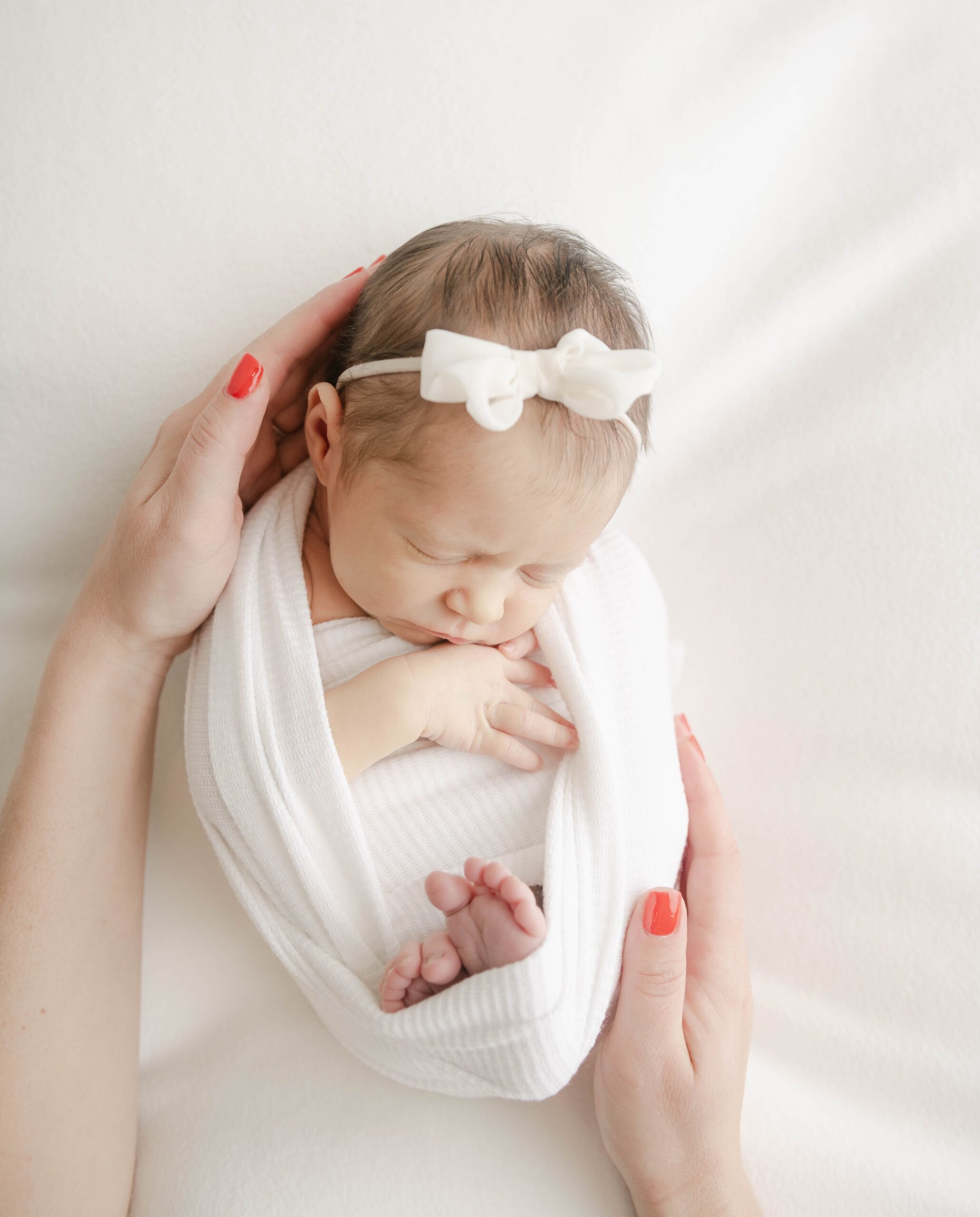 A newborn baby sleeps while mom places her hands around her baby shower venues lancaster pa