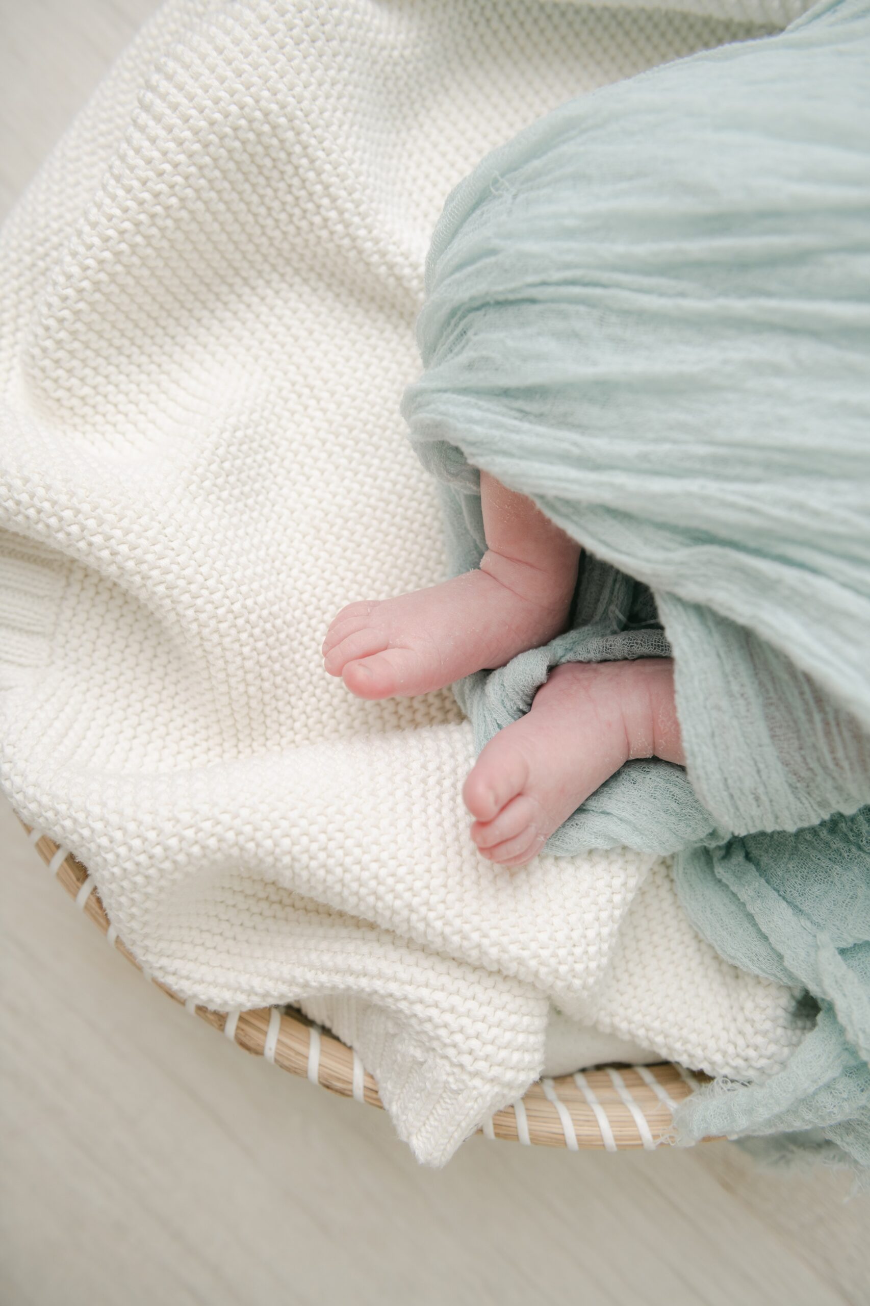 Details of a newborn baby's feet wrapped in a green blanket at one of the baby shower venues west chester pa