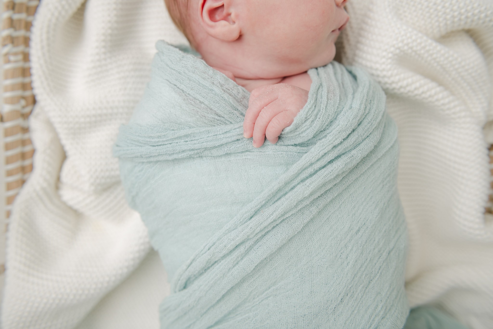 Details of a sleeping newborn baby in a green swaddle from baby shower venues west chester pa