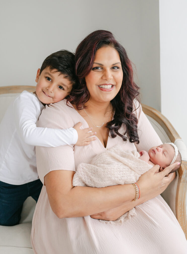 Mother in pink dress, baby and toddler